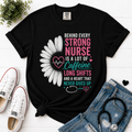 Behind Every Strong Nurse Comfort Colors T-Shirt Black flatlay with stethoscope and sneakers